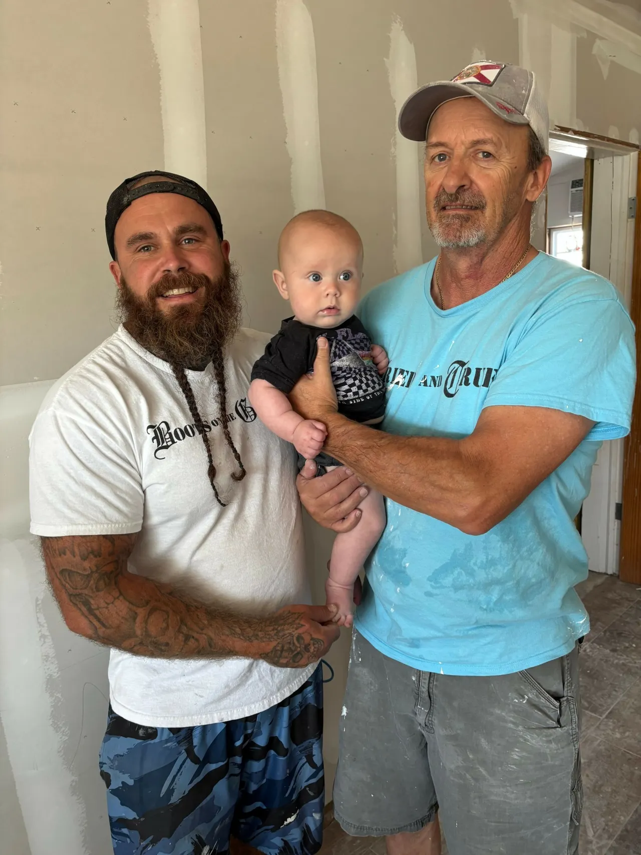 Daniel Vowell and one of his employees holding his baby son